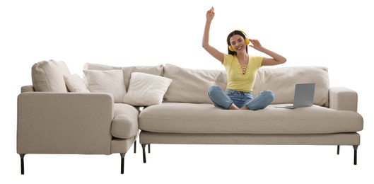 Photo of Young woman with laptop listening to music on comfortable sofa against white background