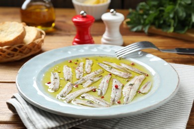 Photo of Tasty pickled anchovies with spices on table, closeup