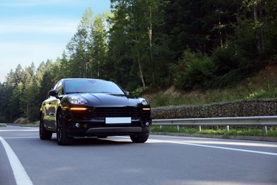 Photo of Picturesque view of asphalt road with modern black car