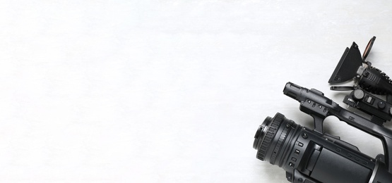 Photo of Modern video camera with flashlight on white background, top view. Space for text