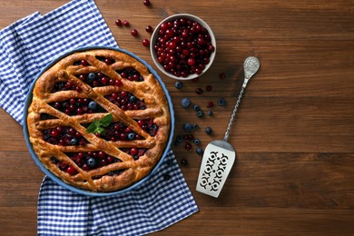 Delicious currant pie with fresh berries on wooden table, flat lay