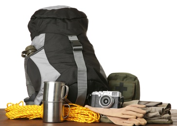 Set with different camping equipment on wooden table against white background