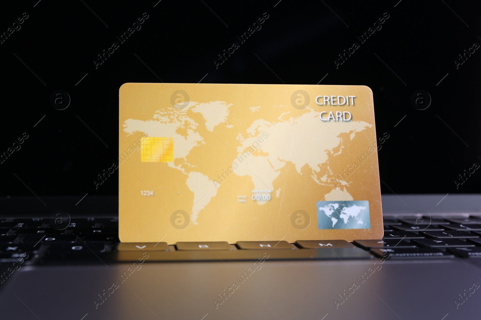 Photo of One plastic credit card on laptop, closeup