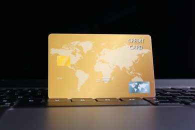 Photo of One plastic credit card on laptop, closeup