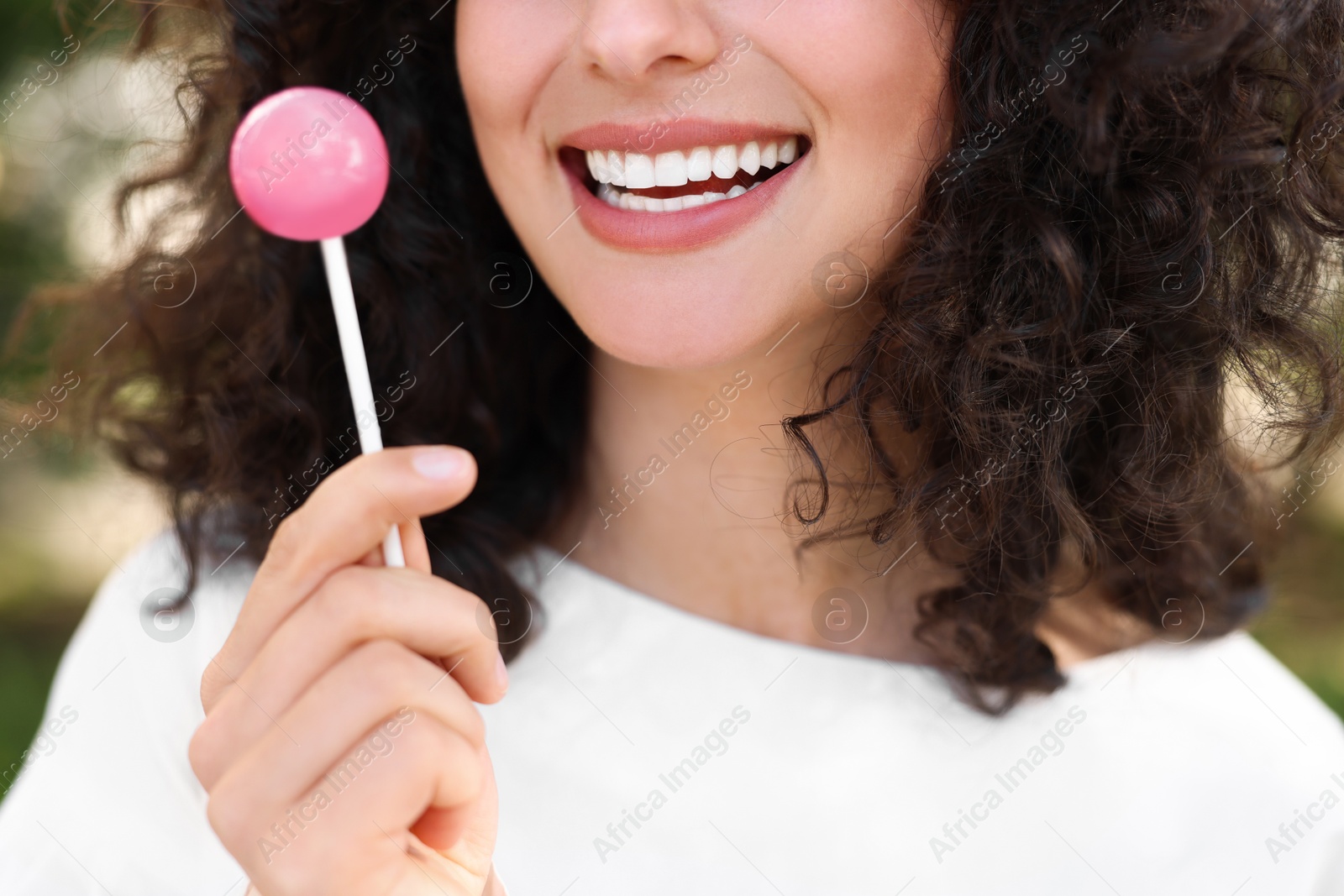 Photo of Woman with tasty lollipop outdoors, closeup view