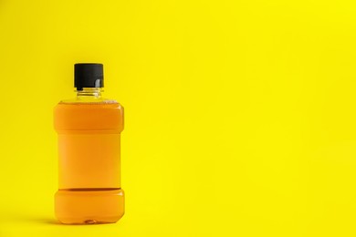Photo of Mouthwash on yellow background, space for text