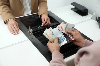 Photo of Man exchanging money in bank, closeup view