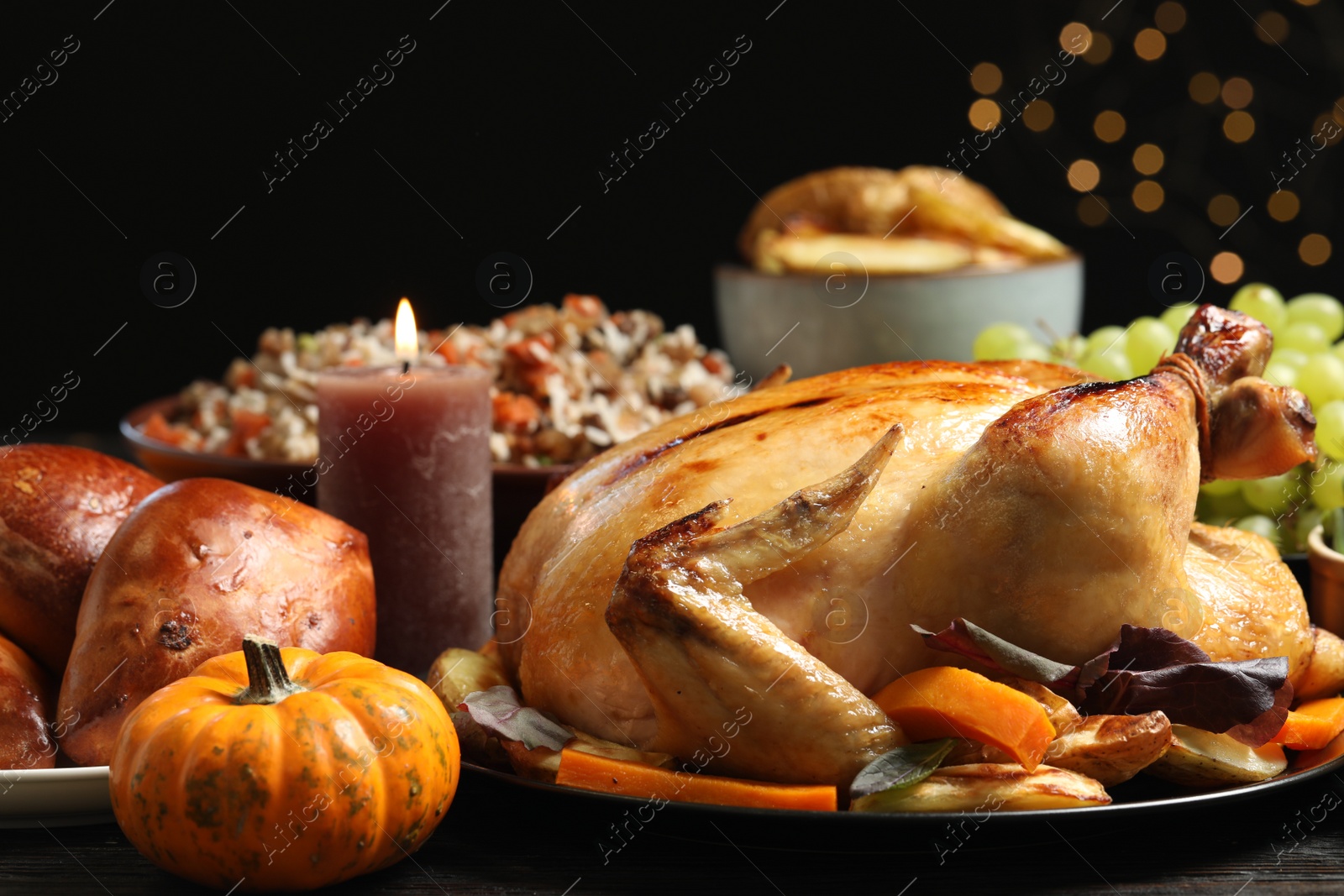 Photo of Traditional Thanksgiving day feast with delicious cooked turkey and other seasonal dishes served on table, closeup