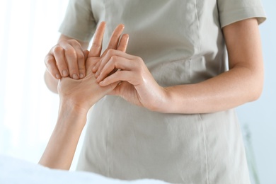 Woman receiving hand massage in wellness center, closeup