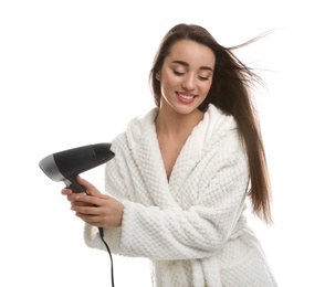 Beautiful young woman using hair dryer on white background