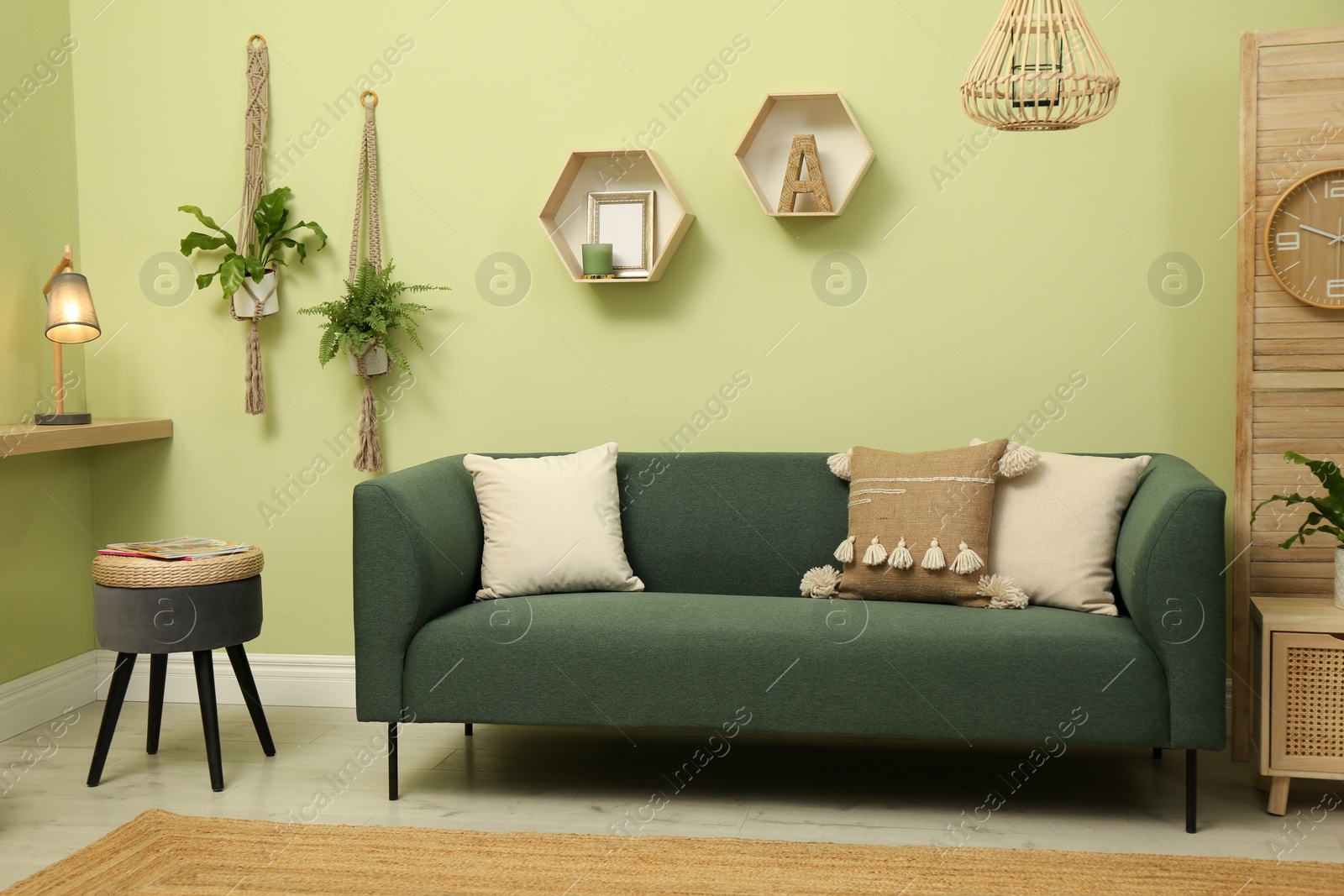 Photo of Living room with comfortable green sofa. Interior design