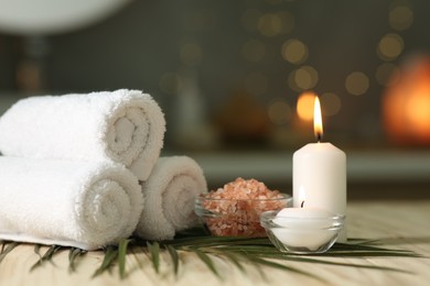 Photo of Composition with different spa products and burning candles on wooden table indoors