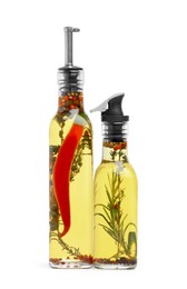 Photo of Glass bottles of cooking oils with spices and herbs on white background