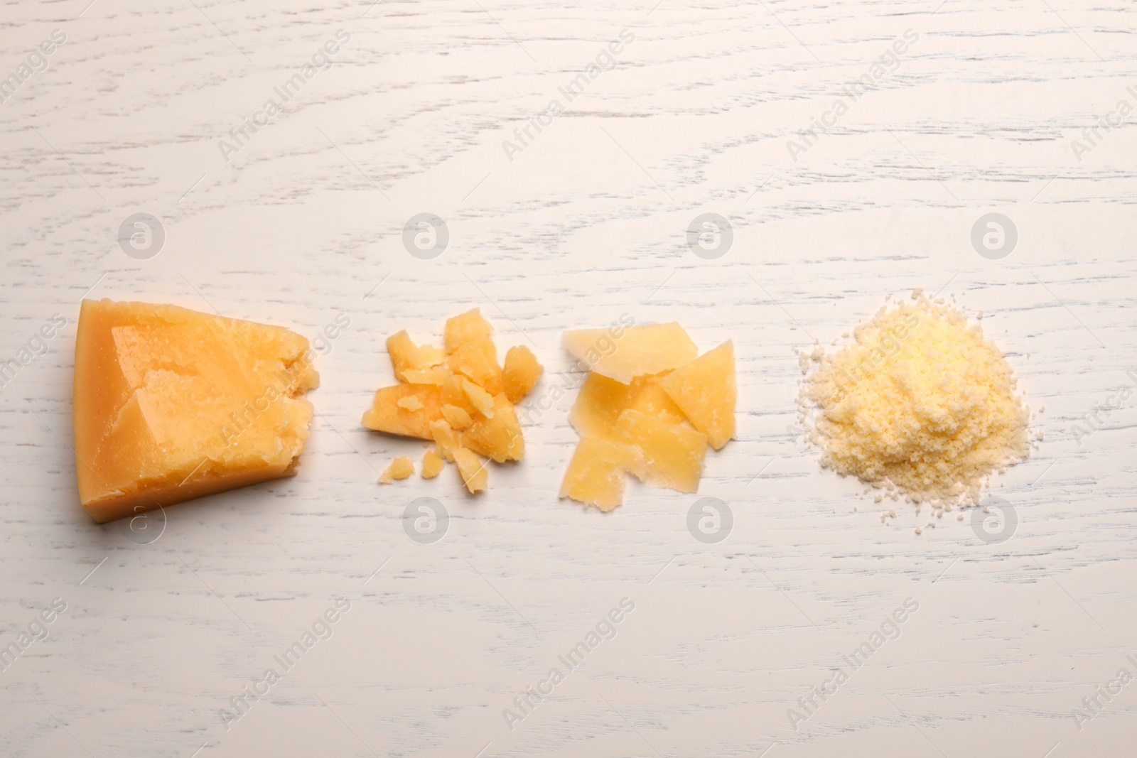 Photo of Delicious parmesan cheese on white wooden table, top view