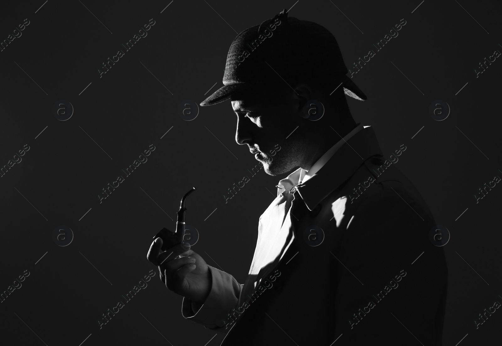 Photo of Old fashioned detective with smoking pipe on dark background, black and white effect