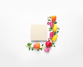 Photo of Beautiful composition with spring flowers and blank card on white background, top view. Space for text