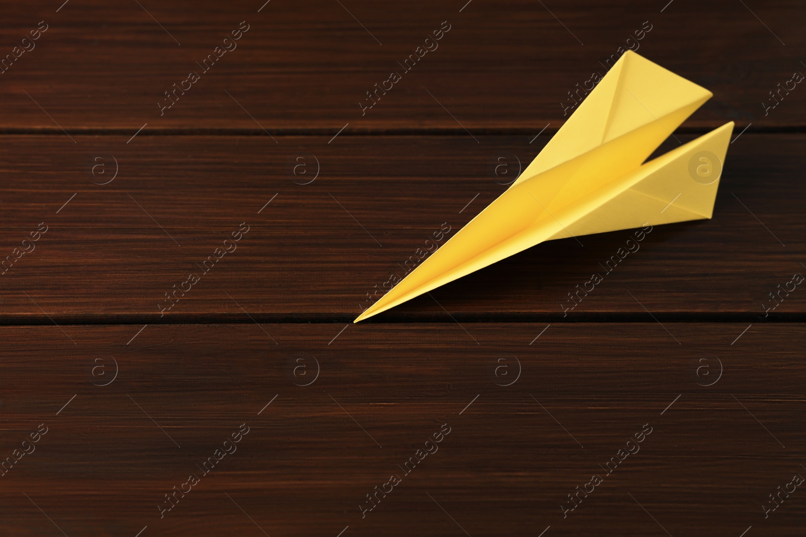 Photo of Handmade paper plane on wooden table. Space for text