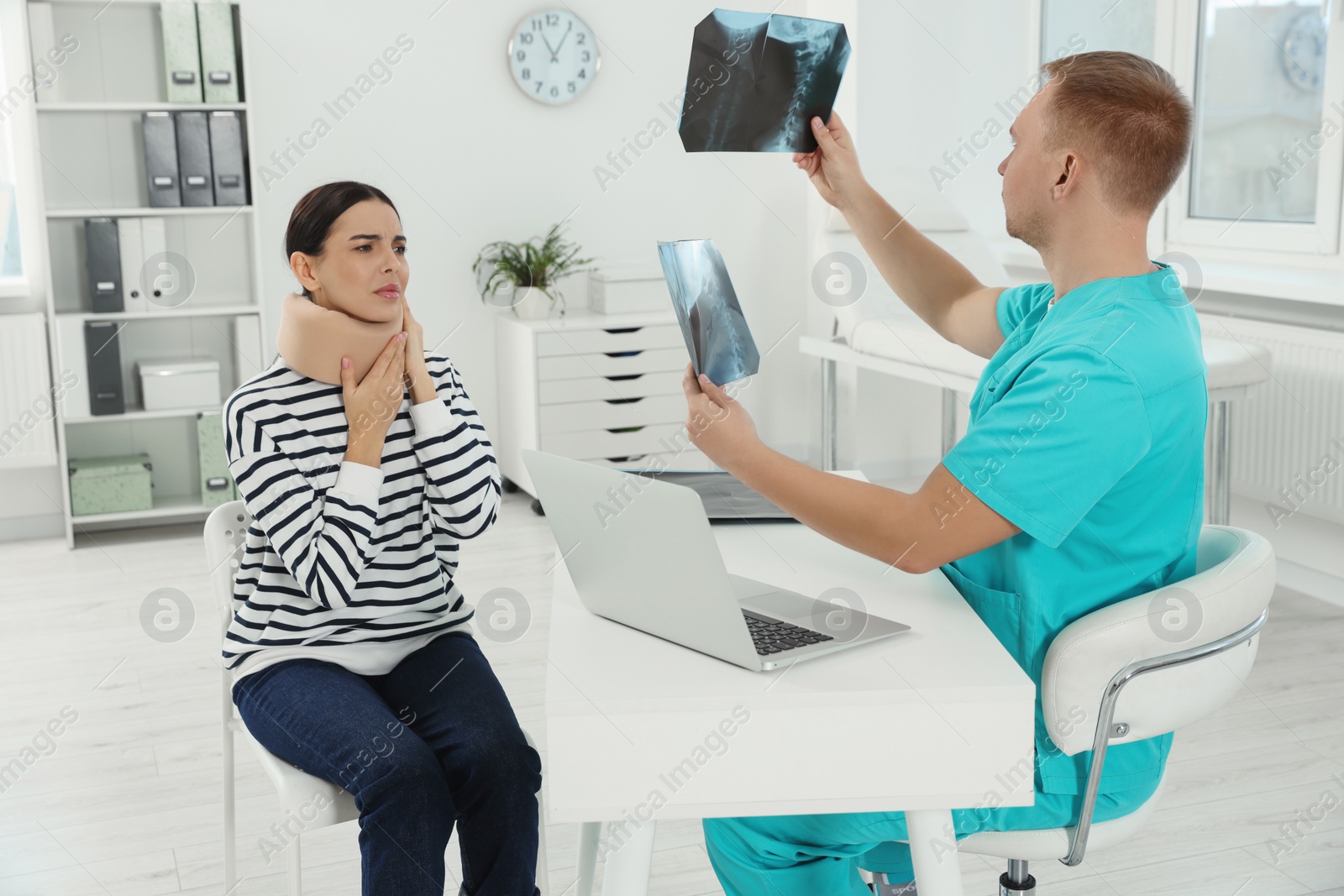 Photo of Doctor with neck MRI images consulting patient in clinic