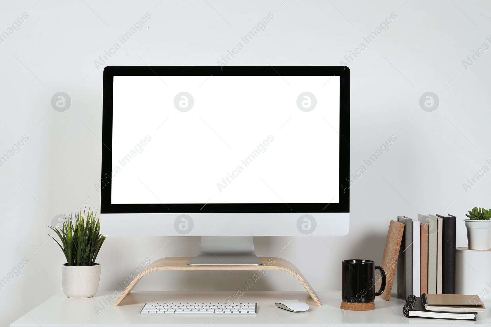 Photo of Cozy workspace with computer and stationery on wooden desk at home