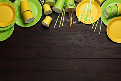Photo of Flat lay composition with disposable tableware on wooden background, space for text