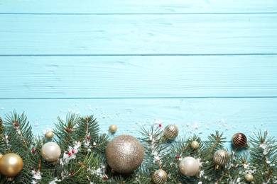 Photo of Fir tree branches with Christmas decoration on light blue wooden background, flat lay. Space for text