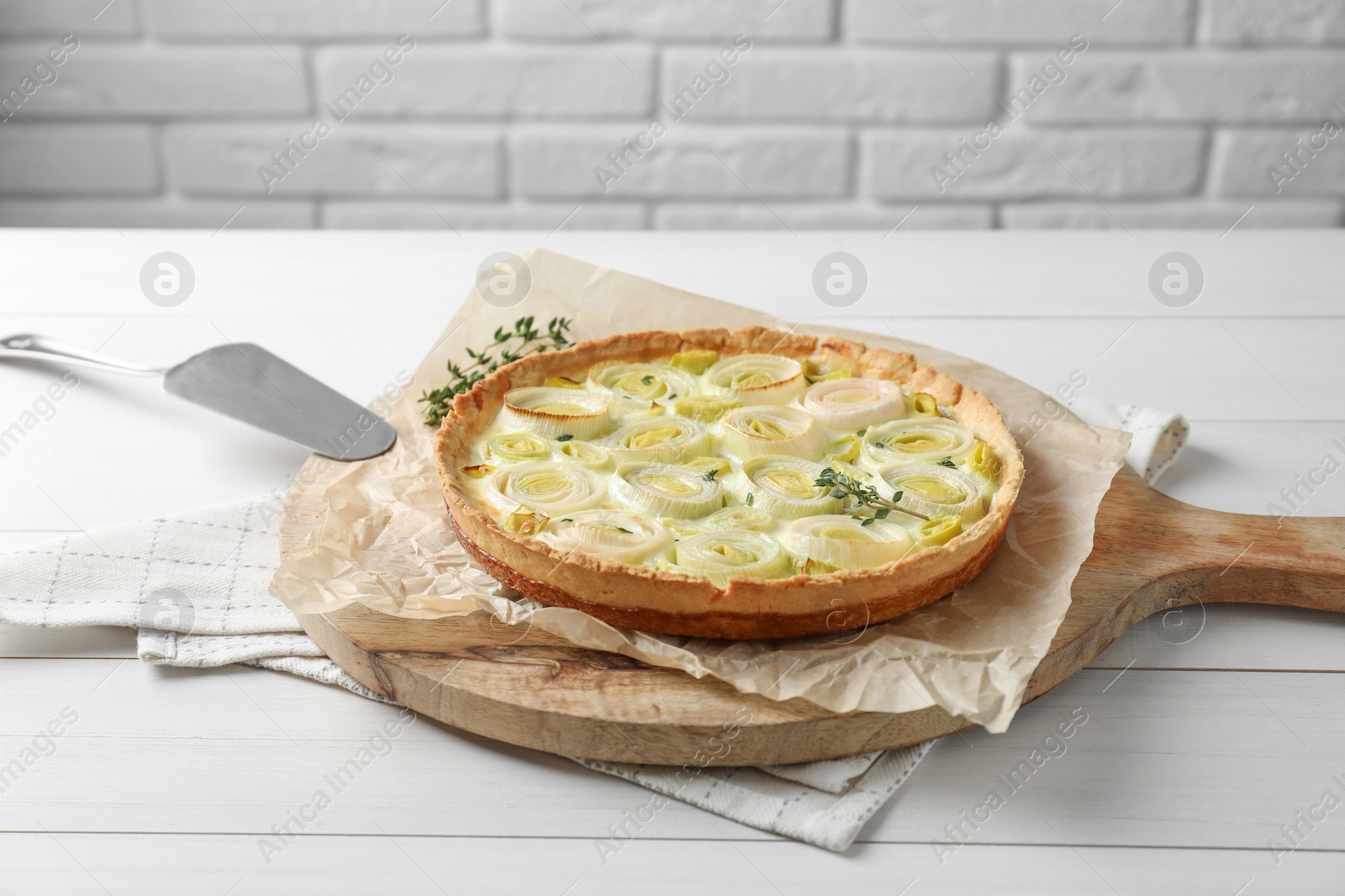 Photo of Tasty leek pie with thyme on white wooden table