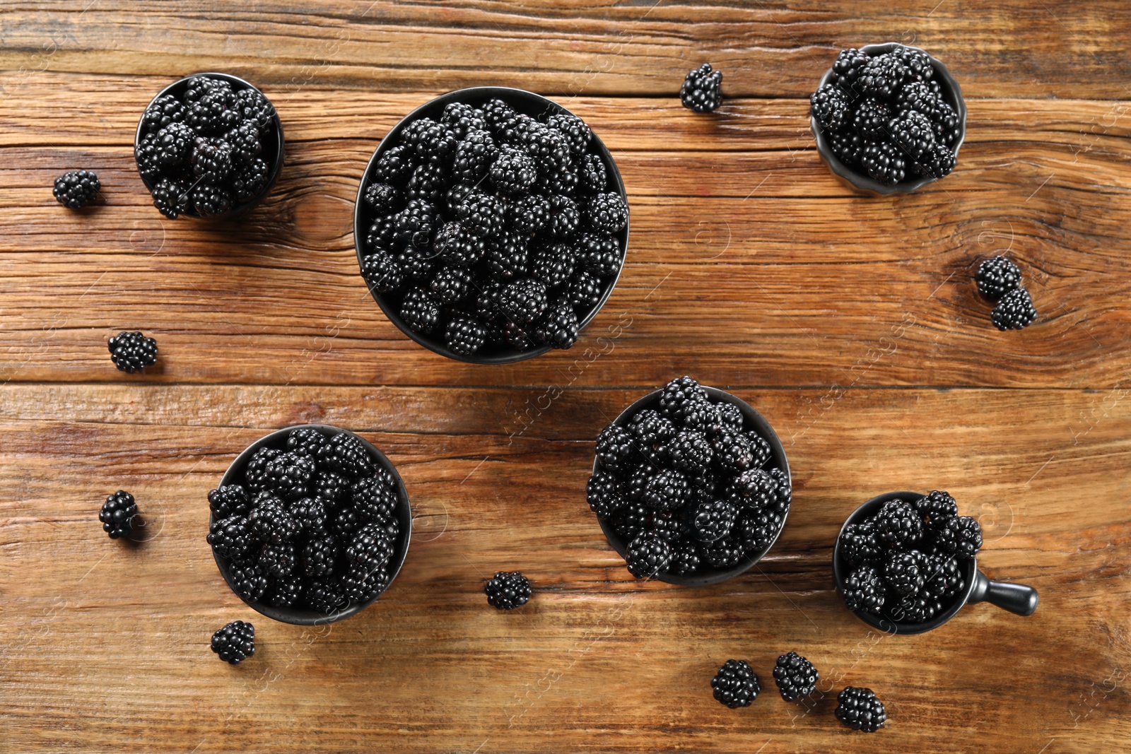 Photo of Ripe blackberries on wooden table, flat lay