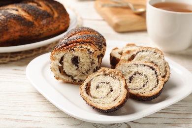 Plate with freshly baked poppy seed roll on table