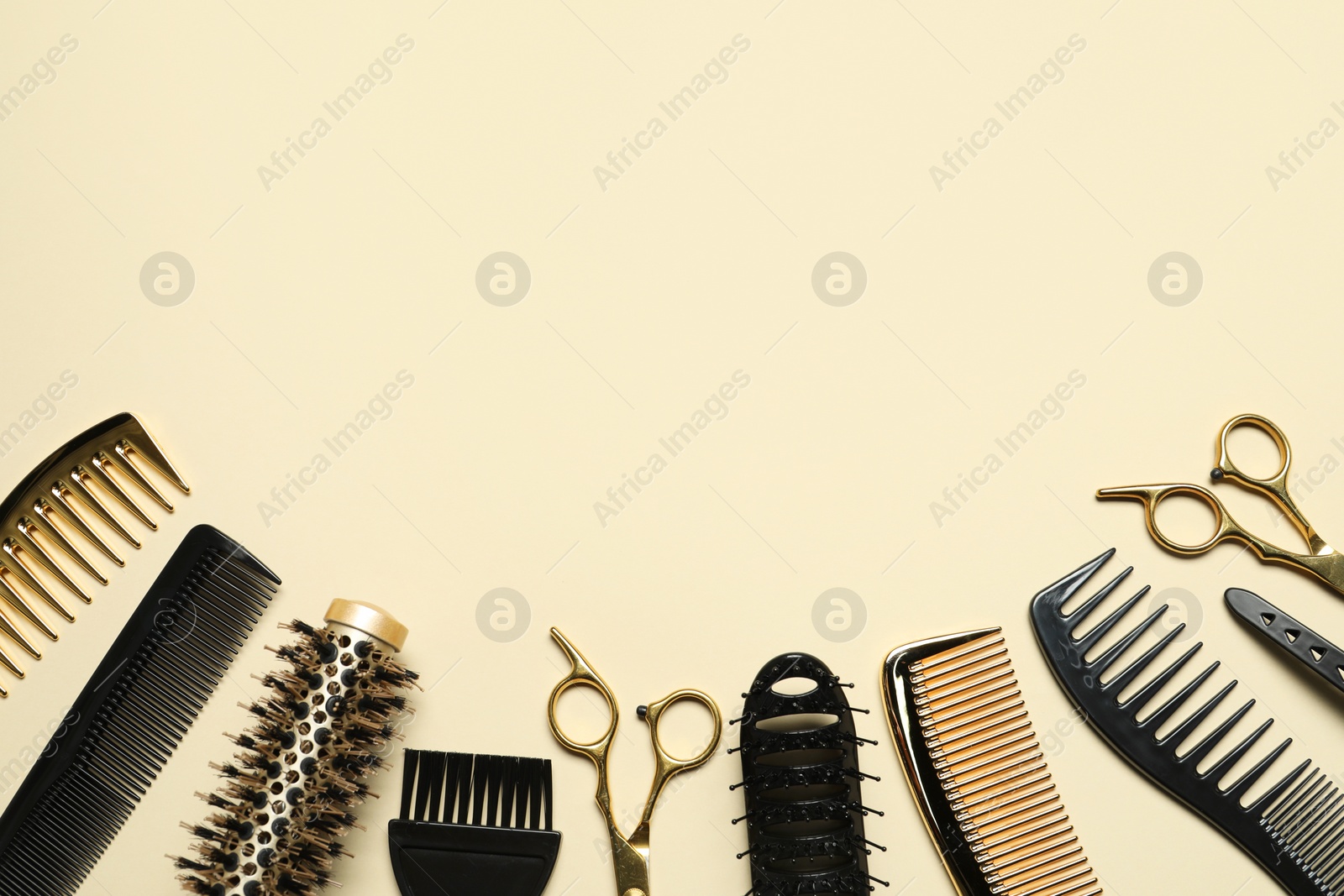 Photo of Hairdressing tools on beige background, flat lay. Space for text