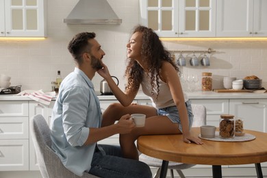 Photo of Lovely couple enjoying time together at table in kitchen