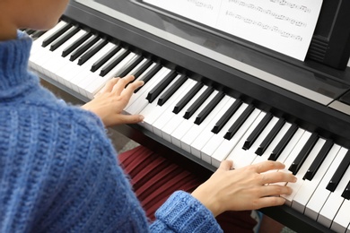 Photo of Young woman playing piano at home, above view