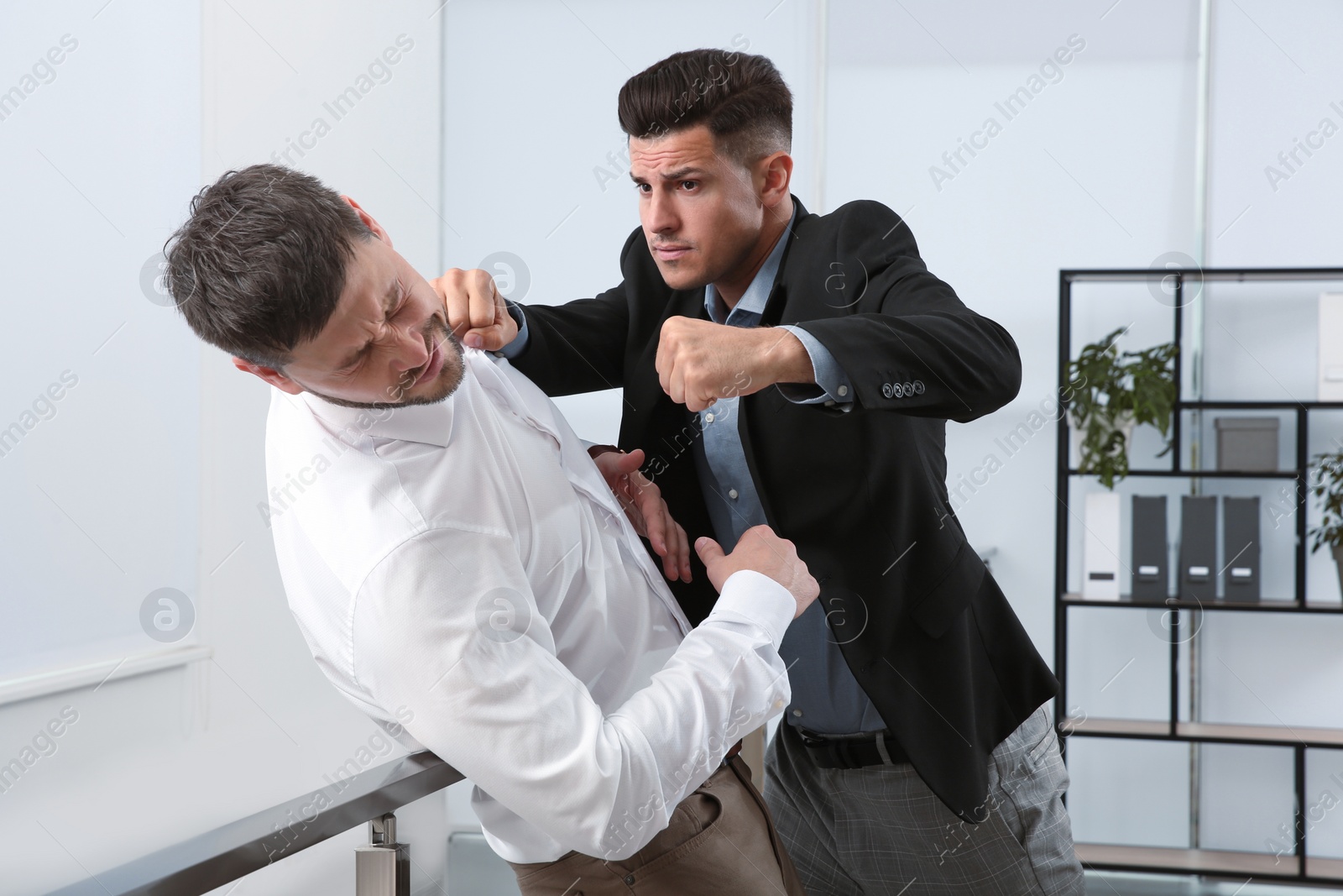 Photo of Emotional colleagues fighting in office. Workplace conflict