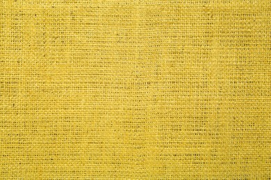 Texture of yellow burlap fabric as background, top view