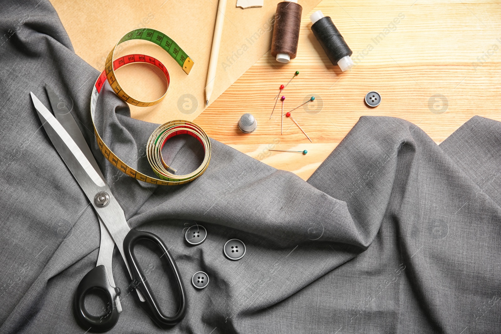 Photo of Composition with fabric and accessories for tailoring on wooden background