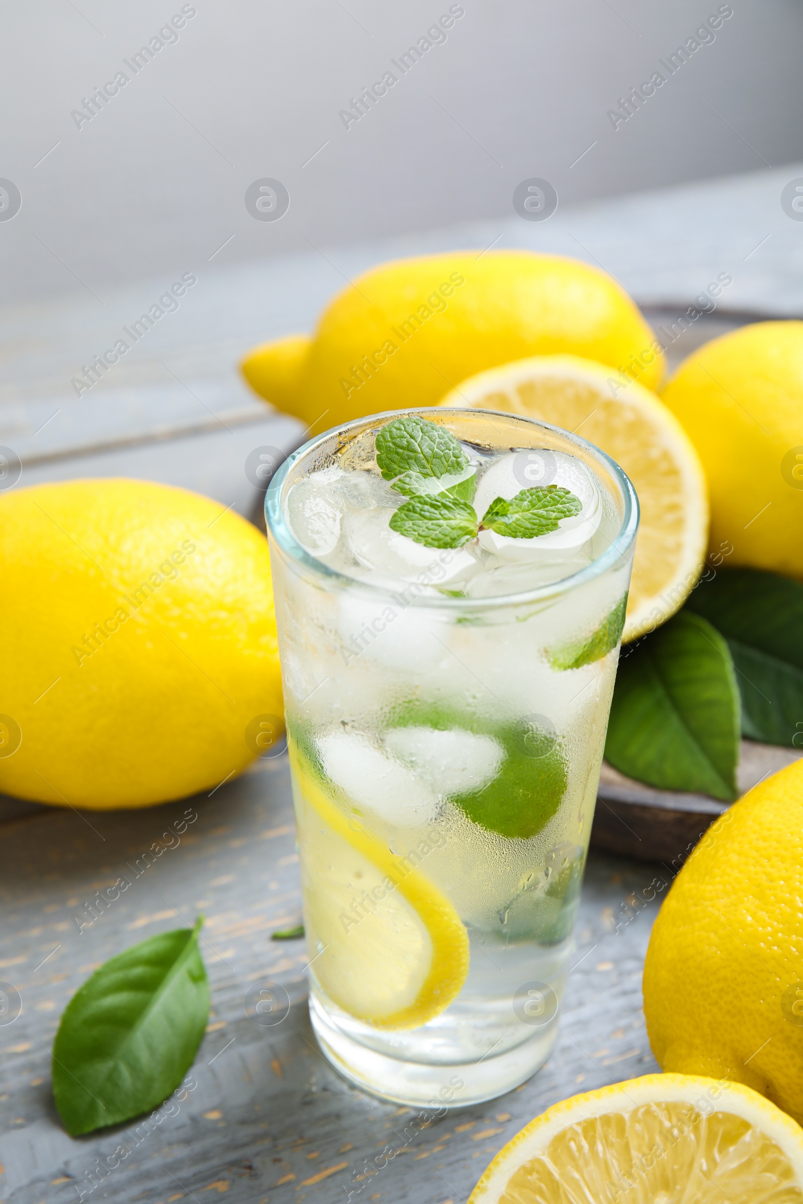 Photo of Cool freshly made lemonade and fruits on grey wooden table