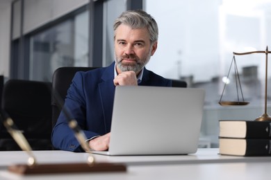 Photo of Handsome lawyer working at table in office