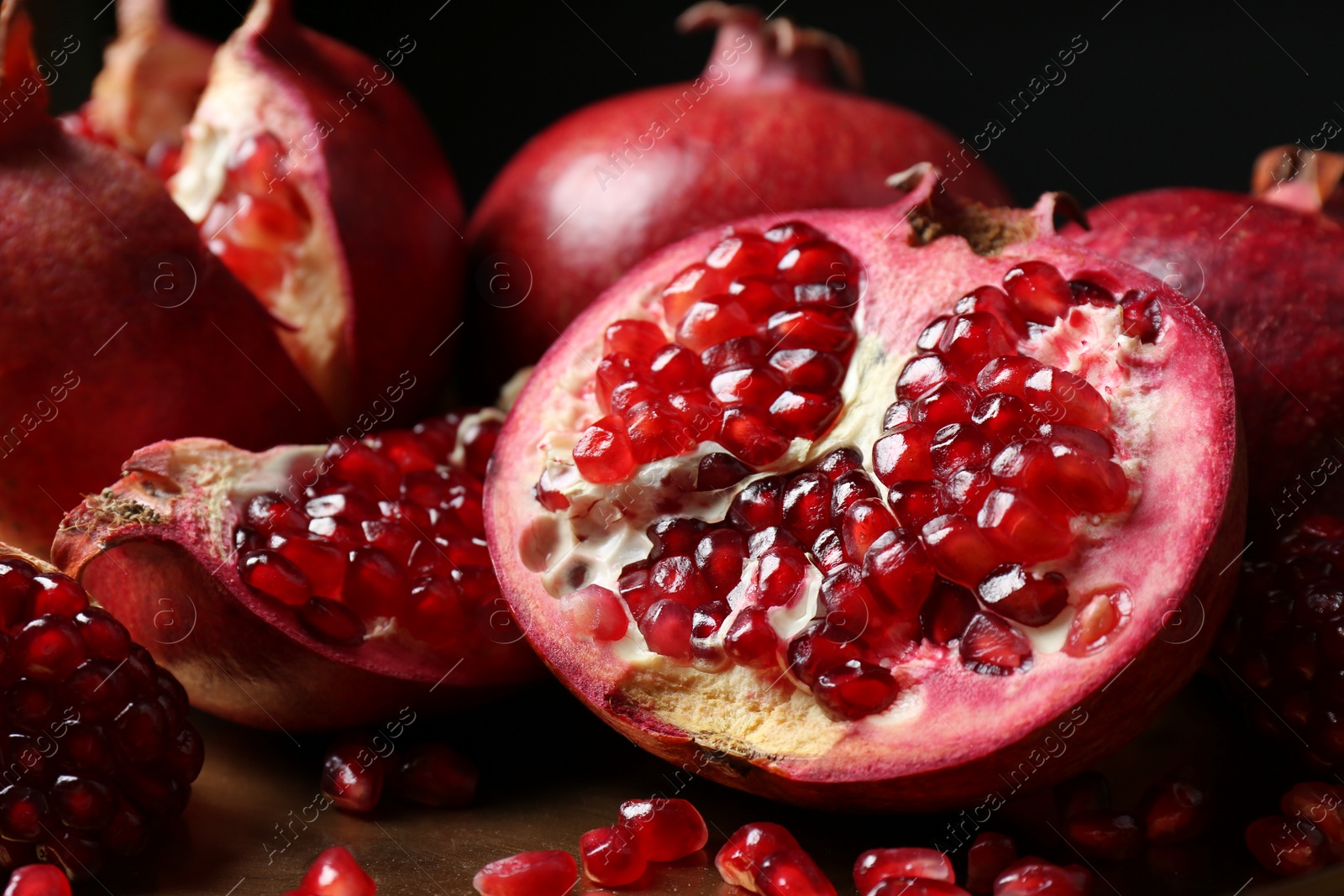 Photo of Delicious ripe pomegranates on table, closeup view