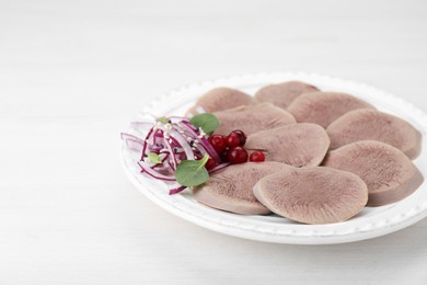 Photo of Tasty beef tongue pieces, berries and red onion on white wooden table, closeup. Space for text