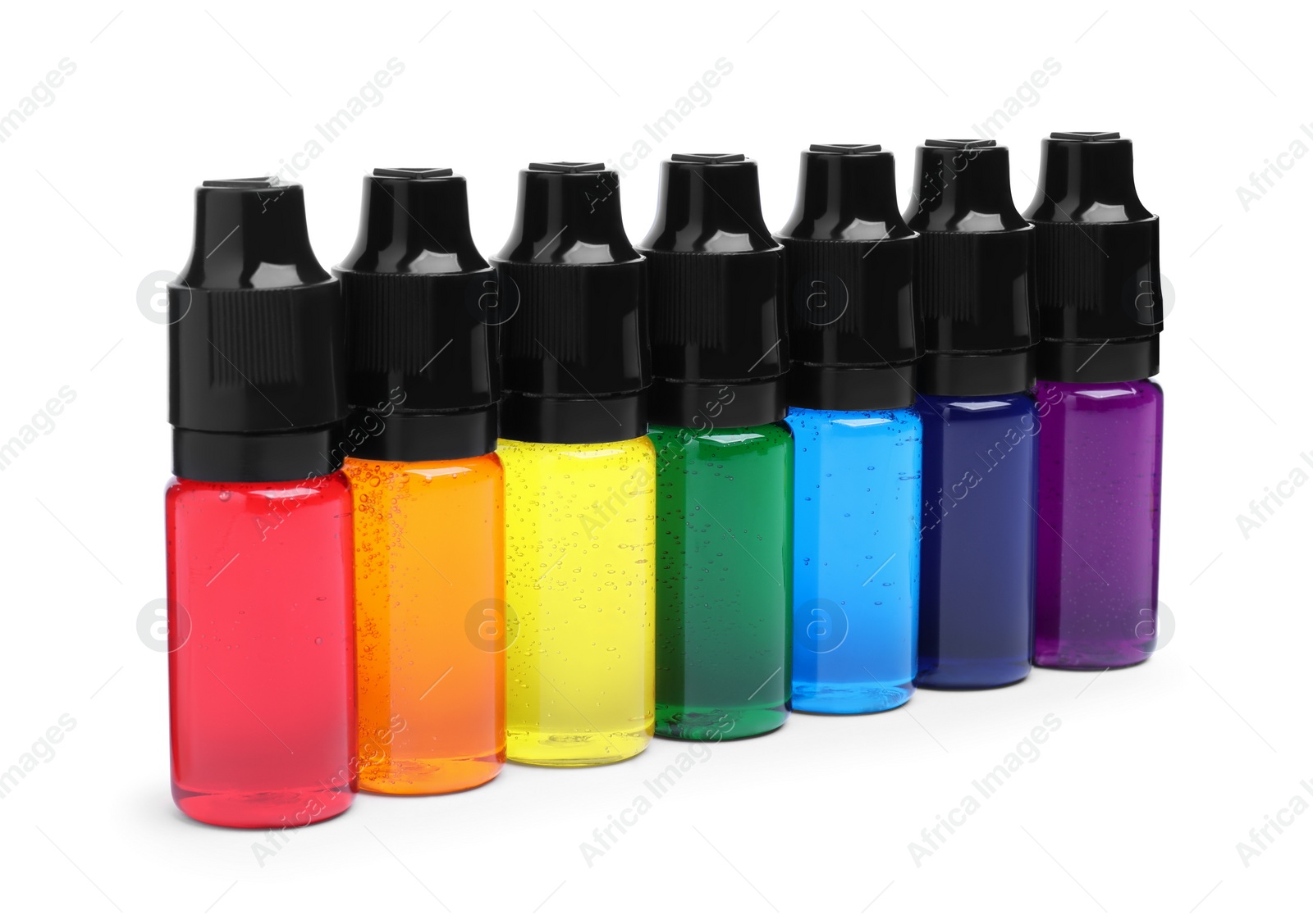 Photo of Bottles with different food coloring on white background