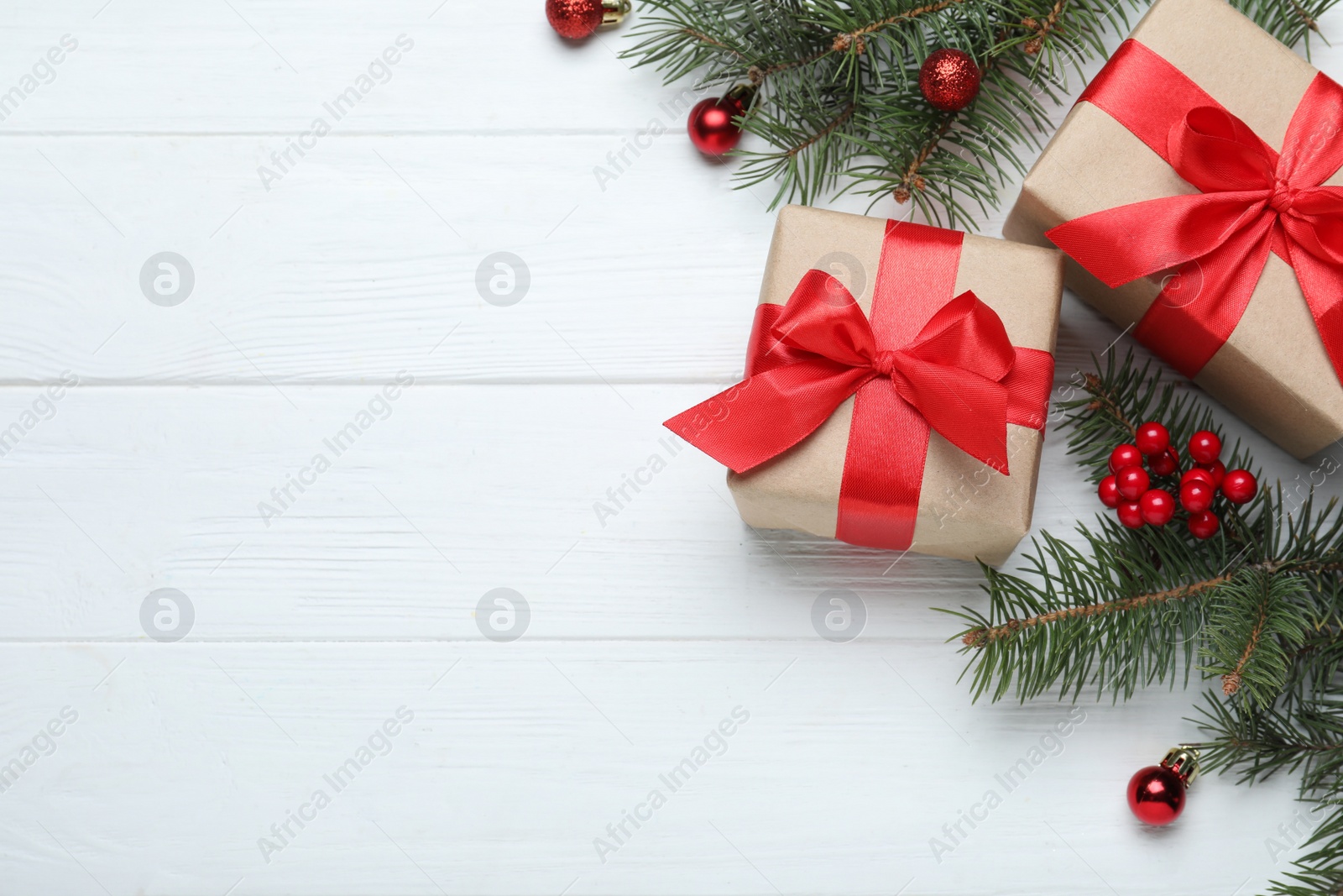 Photo of Flat lay composition with gift boxes and Christmas decorations on white wooden table, space for text