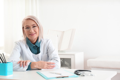 Photo of Portrait of mature female doctor in white coat at workplace