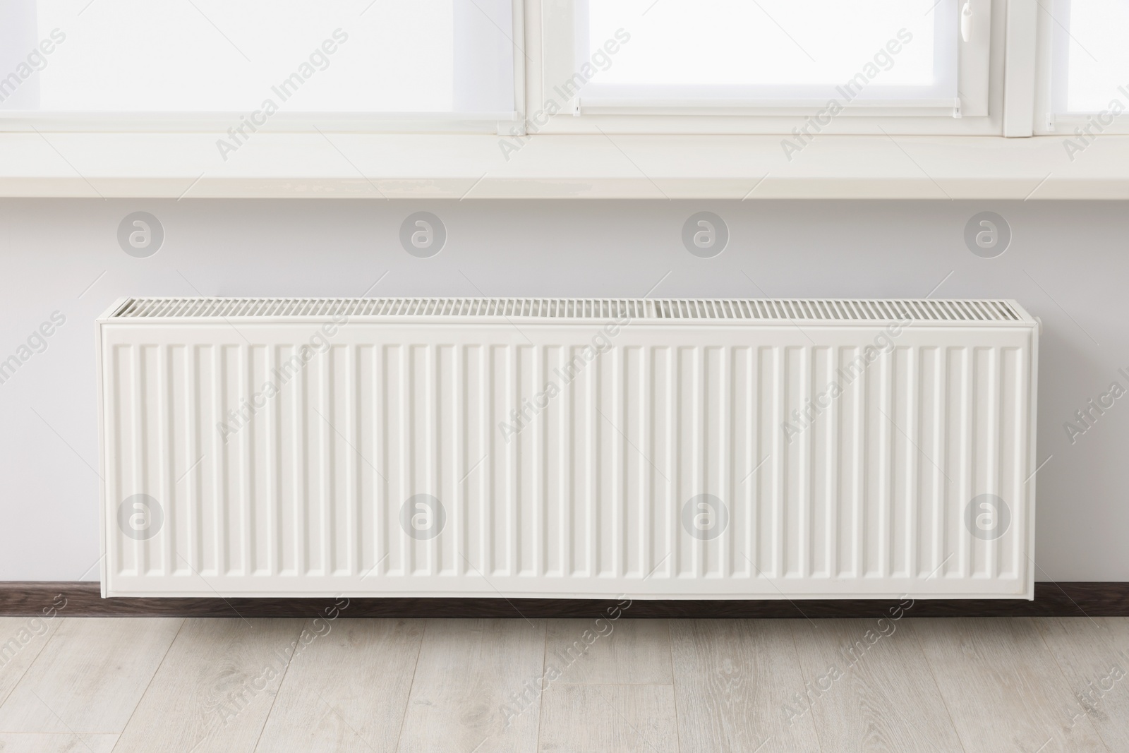 Photo of Modern radiator in room. Central heating system