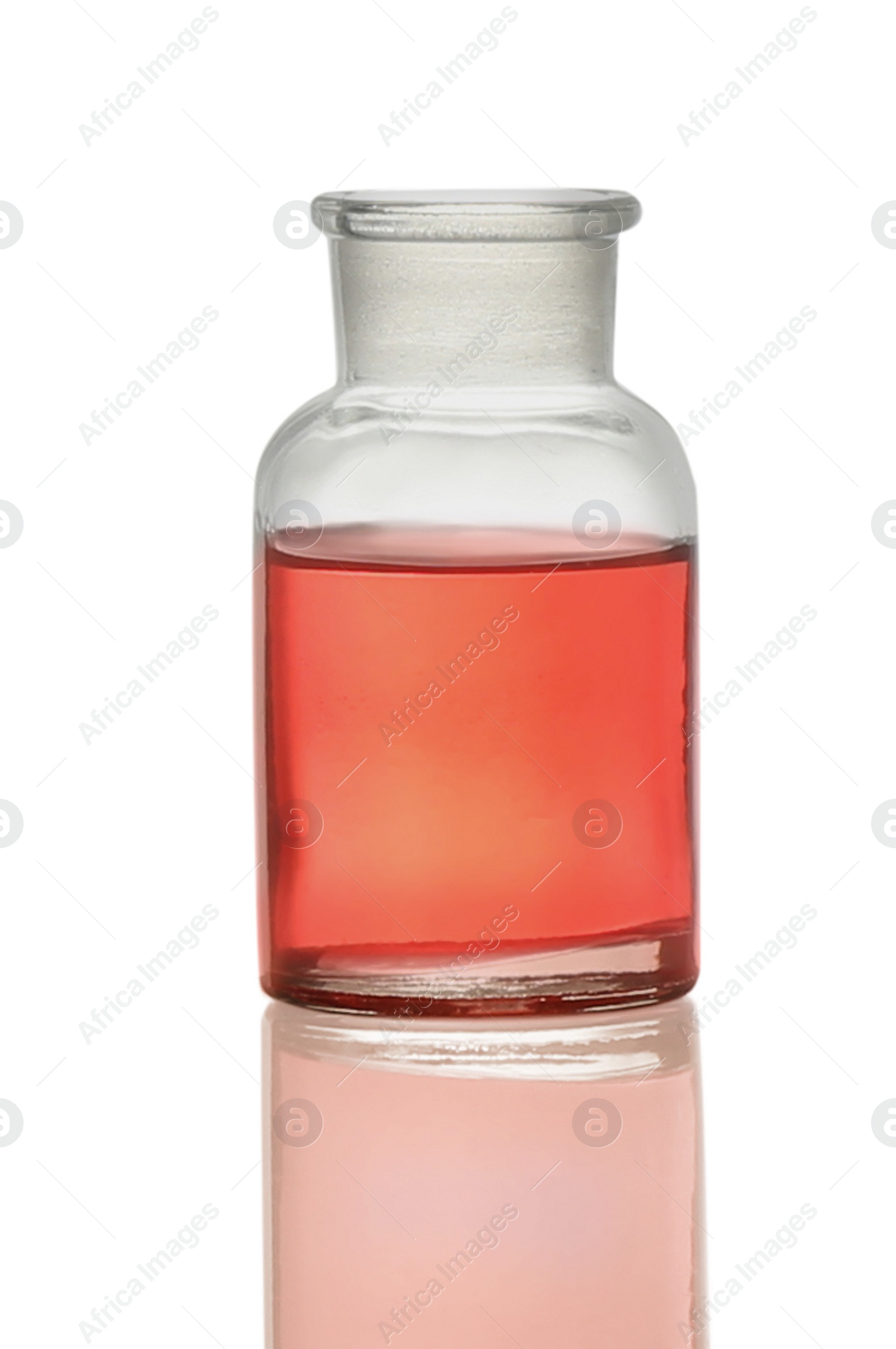 Photo of Apothecary bottle with red liquid isolated on white