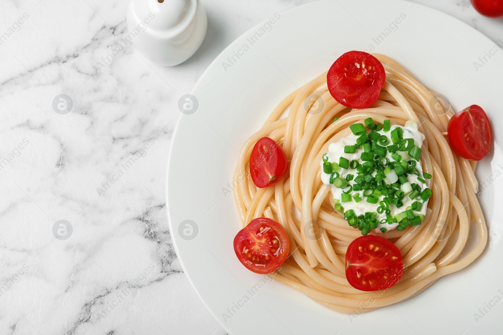 Photo of Delicious spaghetti with sour cream on marble background, flat lay