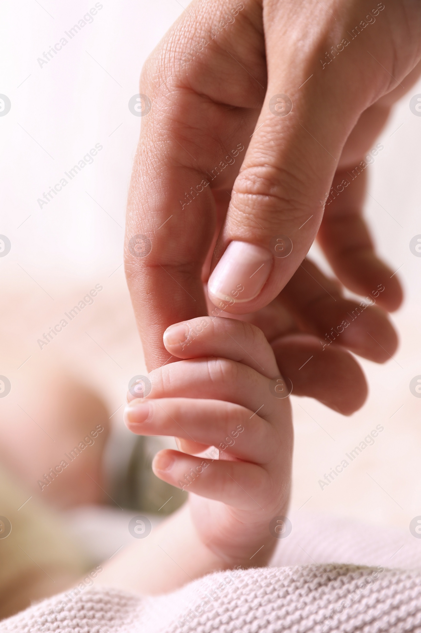 Photo of Mother and her newborn baby on beige knitted plaid, closeup