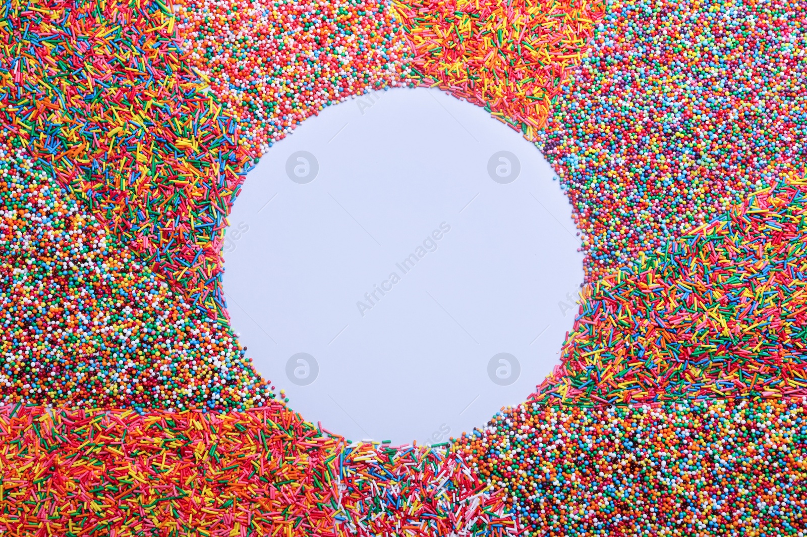 Photo of Frame of colorful sprinkles on light grey background, flat lay with space for text. Confectionery decor