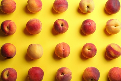 Photo of Fresh ripe peaches on yellow background, flat lay