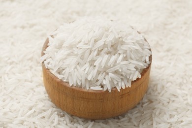 Bowl on raw basmati rice, closeup view