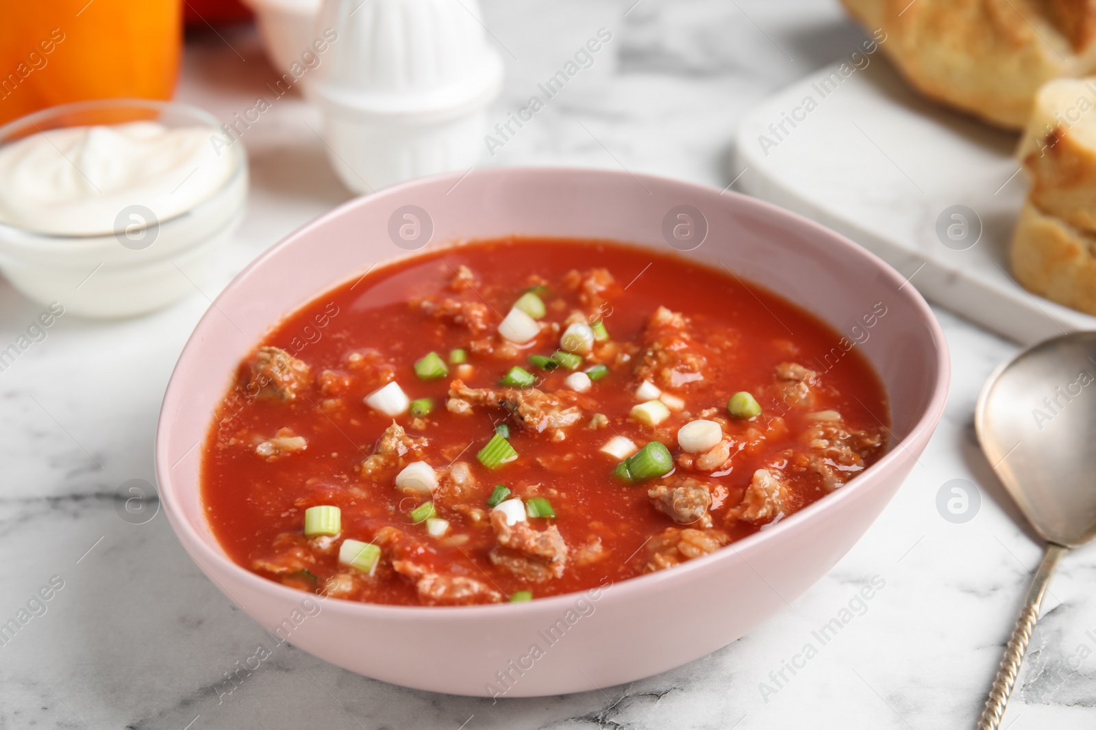 Photo of Bowl of delicious stuffed pepper soup on white marble table