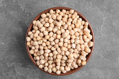 Photo of Bowl with dried peas on grey background, top view